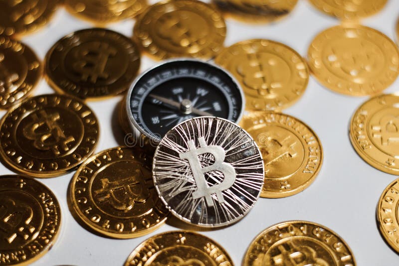 Moneta di Bitcoin vicino alla bussola immagini stock