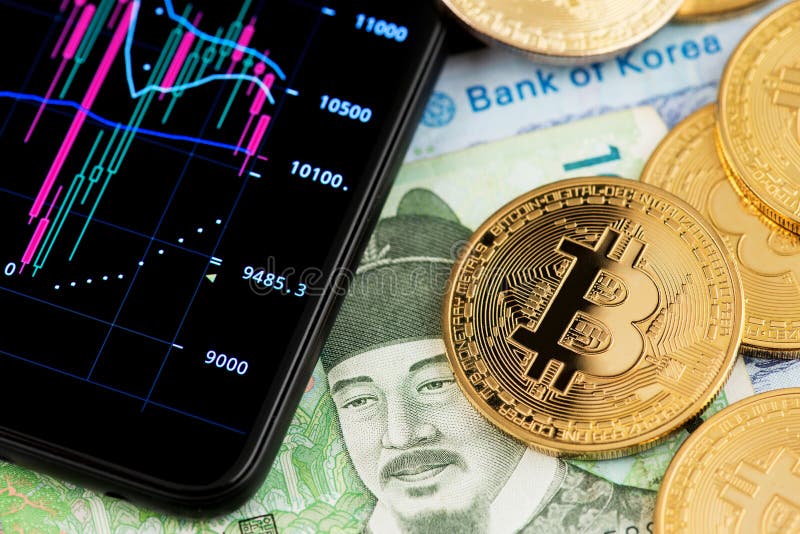 Monete in valuta BTC e in corea del Sud Banconote in valuta coniate accanto al cellulare