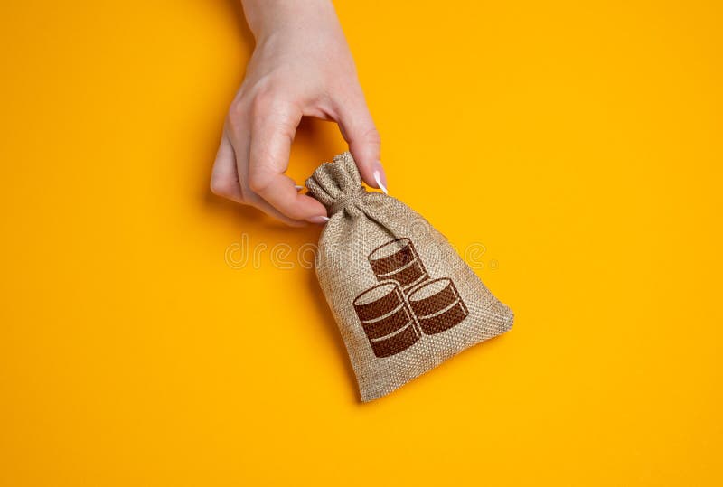 Money bag in woman's hand on empty yellow background. royalty free stock image