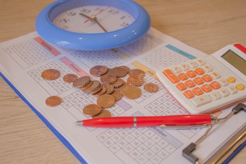 Money, Calculator and Pen on the Calendar. Coin Stack with a Clock