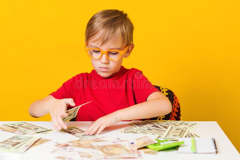 Money for future education. Cute boy acount his money. Financial literacy of children