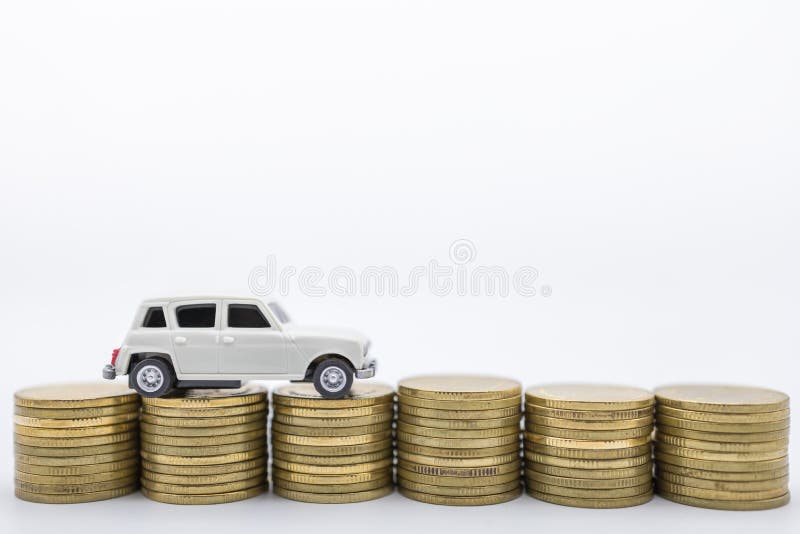 Money, Loan and Saving concept. CLose up of white miniature mini car toy on top of row of stack of gold coins on white background royalty free stock image Money, Loan and Saving concept. CLose up of white miniature mini car toy on top of row of stack of gold coins on white background royalty free stock image