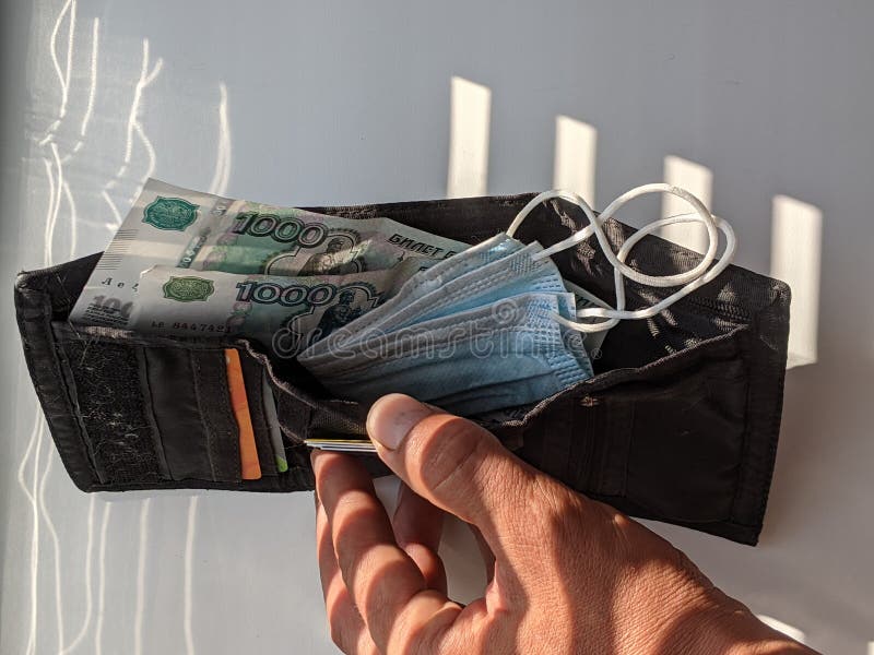 Money and a Mask, a Wallet with Money and a Medical Mask. Stock Photo