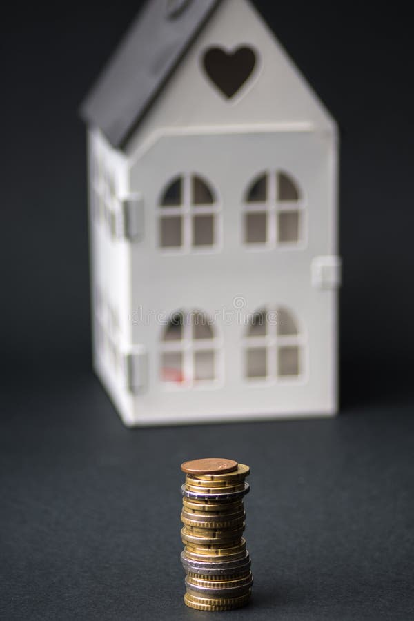 Money next to a small house.stack of euro coins, .mortgage concept royalty free stock images Money next to a small house.stack of euro coins, .mortgage concept royalty free stock images