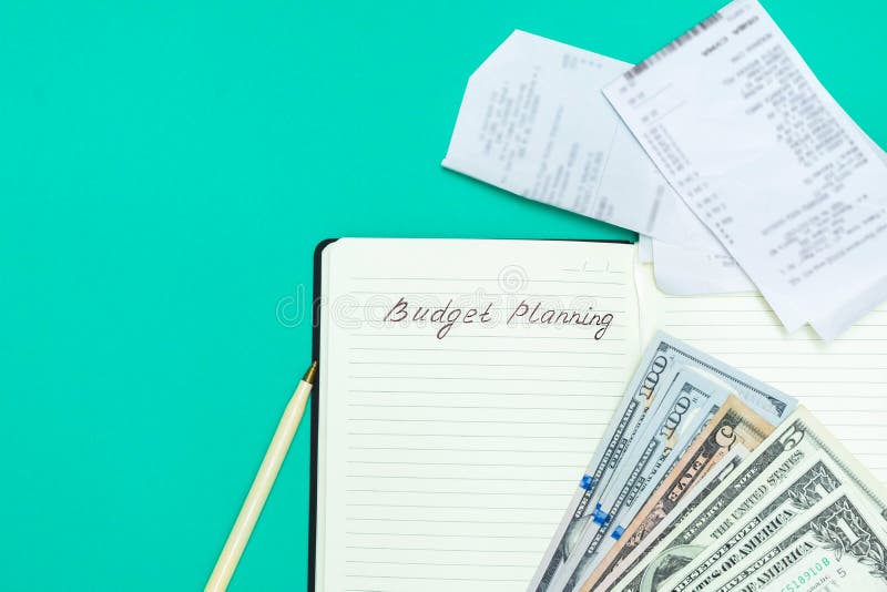 Money, pen, receipts and notepad with handwritten words Budget Planning on green background