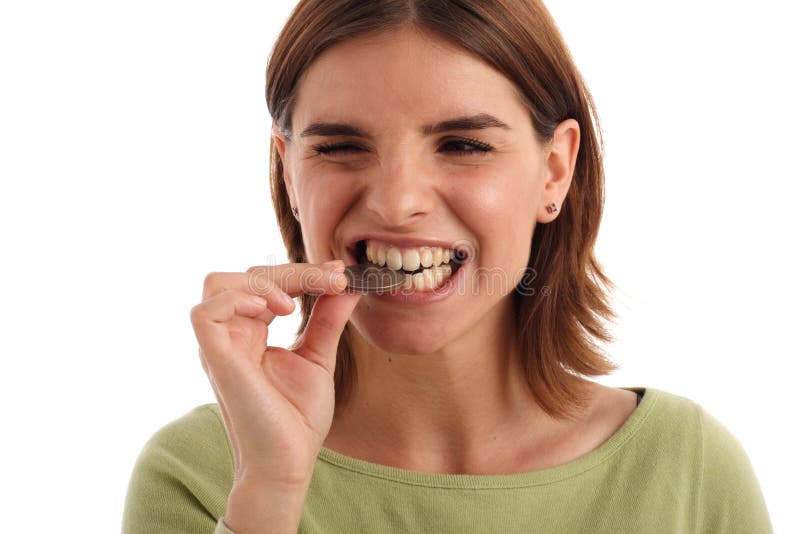 Stock photo of a young woman biting silver dollar. Dought stock images, royalty-free photos and pictures