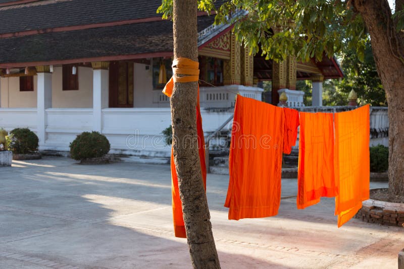 Buddhist monks orange robes drying on washing lines at monastery in Laos. High quality photo. Buddhist monks orange robes drying on washing lines at monastery in Laos. High quality photo