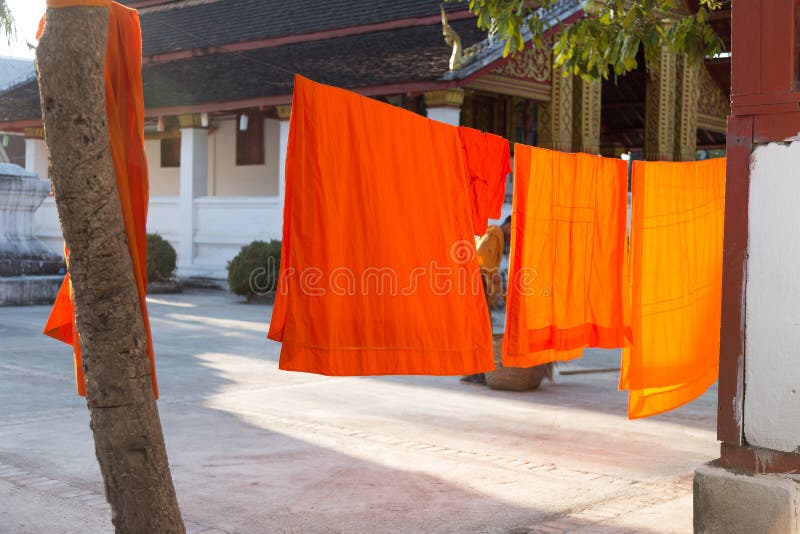 Buddhist monks orange robes drying on washing lines at monastery in Laos. High quality photo. Buddhist monks orange robes drying on washing lines at monastery in Laos. High quality photo