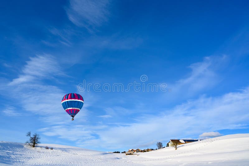 Mongolfiera sopra paesaggio innevato ed il piccolo villaggio rurale, Baviera, Germania immagini stock libere da diritti Mongolfiera sopra paesaggio innevato ed il piccolo villaggio rurale, Baviera, Germania immagini stock libere da diritti
