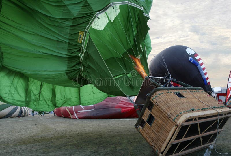 Mongolfiera verde, canestro sulla terra, fiamma sul bruciatore fotografie stock Mongolfiera verde, canestro sulla terra, fiamma sul bruciatore fotografie stock