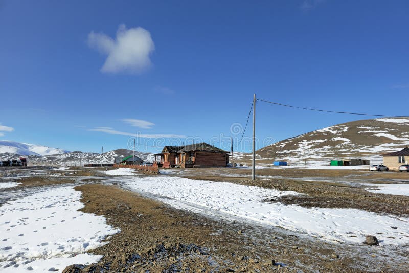 Mongolian village in the snowy steppe. The border area from Mongolia. Realistic village life. Authentic village, houses in the near the highway across the border with Russia. Mongolian village in the snowy steppe. The border area from Mongolia. Realistic village life. Authentic village, houses in the near the highway across the border with Russia