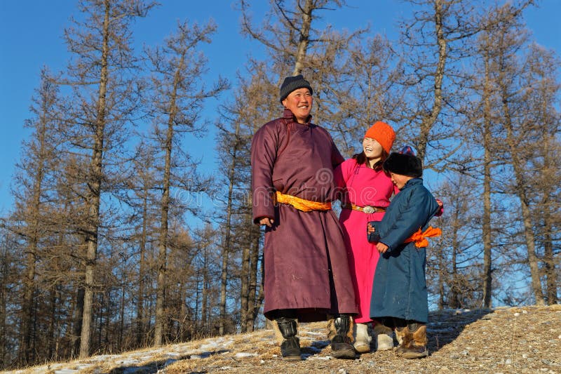 Mongolian people in traditional clothes in a forest landscape