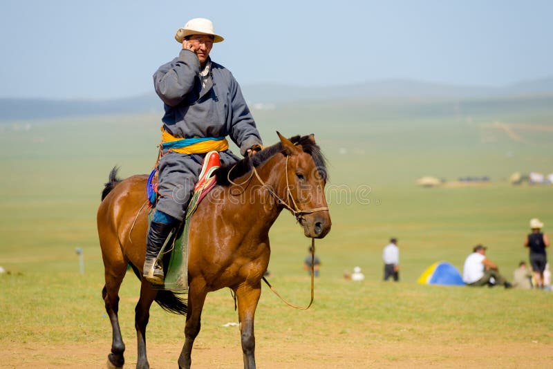 Mongools Personenvervoerpaard Gebruikend Mobiele Telefoon stock afbeeldingen Mongools Personenvervoerpaard Gebruikend Mobiele Telefoon stock afbeeldingen