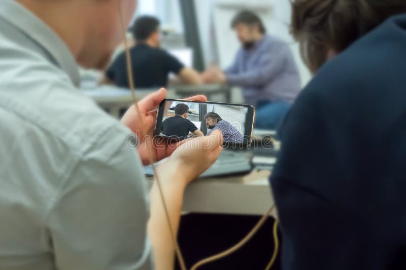 Monitoring education process with mobile phone. Record secretly on mobile phone. Mobile espionage. Hacker crack access stock photography Monitoring education process with mobile phone. Record secretly on mobile phone. Mobile espionage. Hacker crack access stock photography