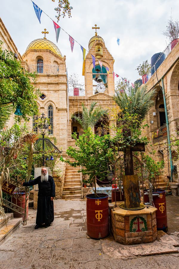 ST. GERASIM MONASTERY, ISRAEL - MARCH 2, 2020: Monk in Motastyr courtyard. The Jerusalem Orthodox Church, Israel. The monastery was built 1500 years ago. The dome and bell tower are crowned with crosses. ST. GERASIM MONASTERY, ISRAEL - MARCH 2, 2020: Monk in Motastyr courtyard. The Jerusalem Orthodox Church, Israel. The monastery was built 1500 years ago. The dome and bell tower are crowned with crosses