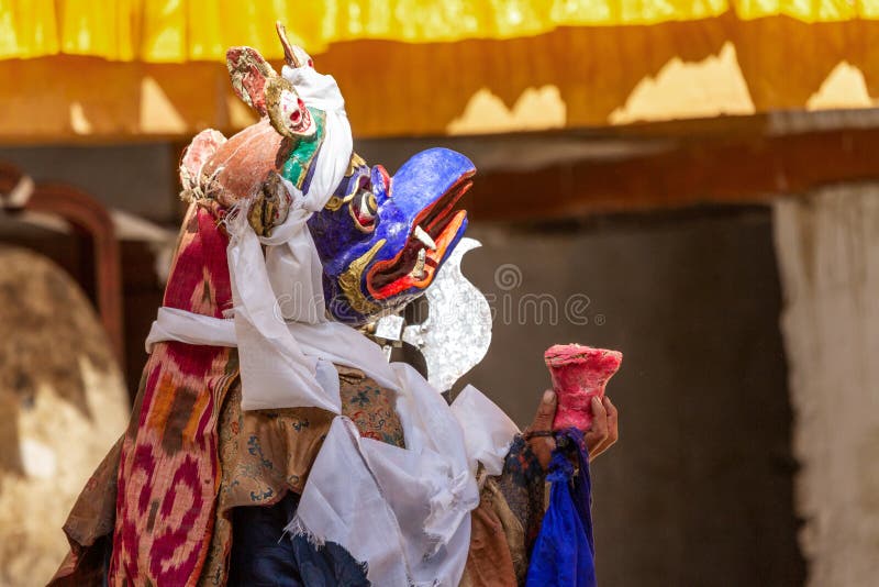 Monk in Garuda mask with ritual axe parashu or elephant goad ankusha performs religious mystery dance of Tantric Tibetan Buddh