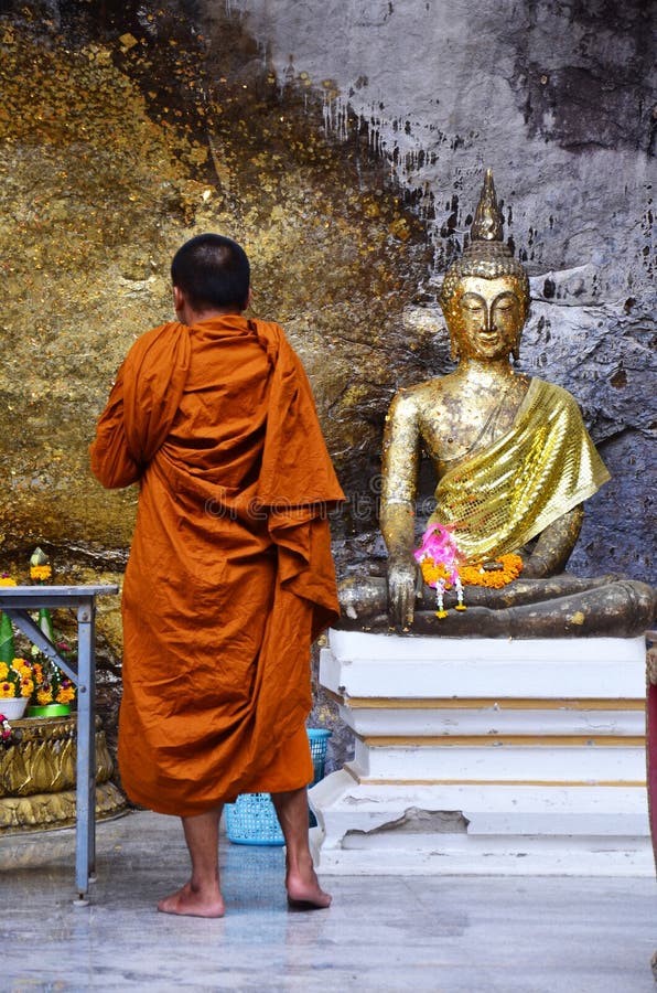 Monk Respect Praying And Gild Cover With Gold Leaf At Lord Buddha Image