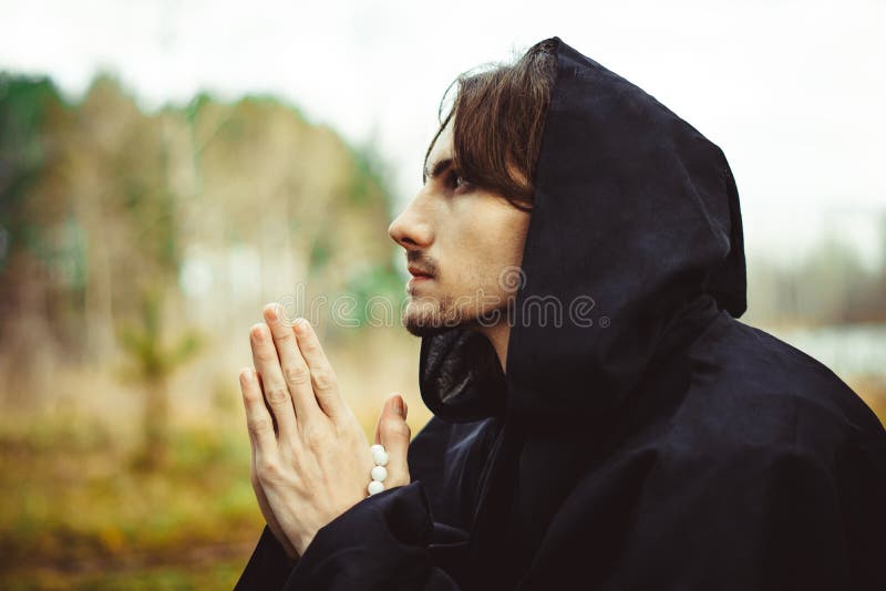 A monk in robes praying in the woods stock photos