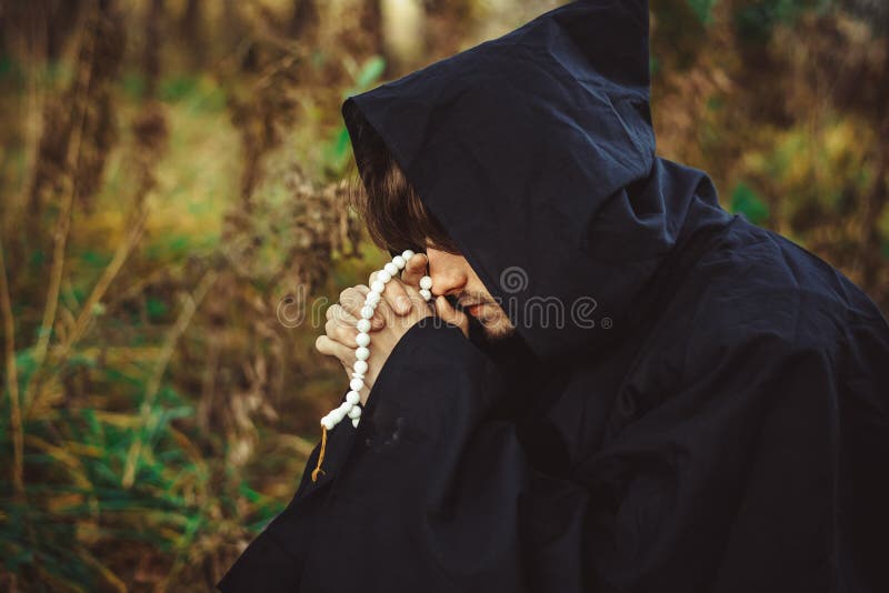 A monk in robes praying in the woods royalty free stock images