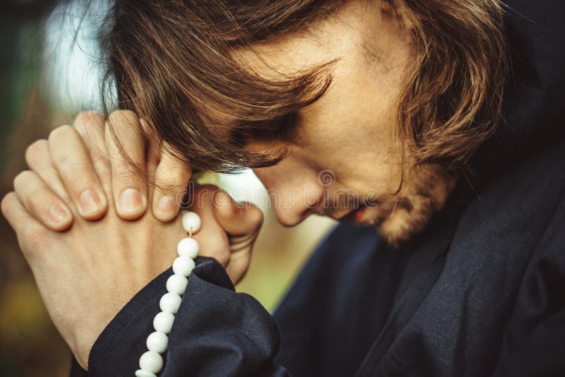 A monk in robes praying in the woods stock photo