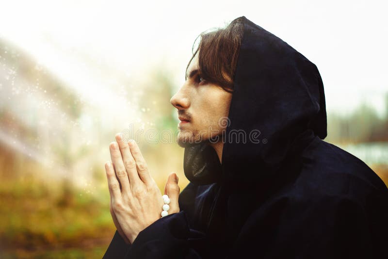 A monk in robes praying in the woods royalty free stock photo