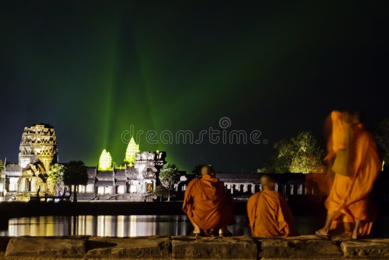 Monks watch the evening light show at Angkor ruins royalty free stock image