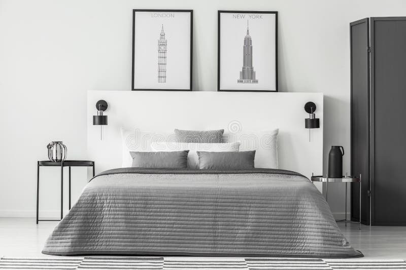 Monochromatic bedroom interior with posters