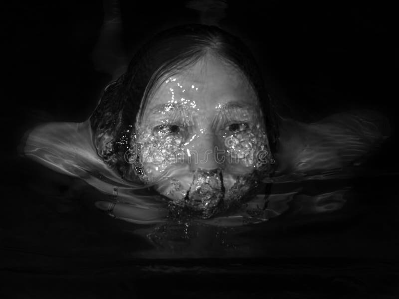 Monochrome image of a woman floating in water royalty free stock photography