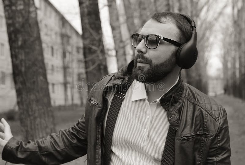 Monochrome человек бороды слушает музыка в парке