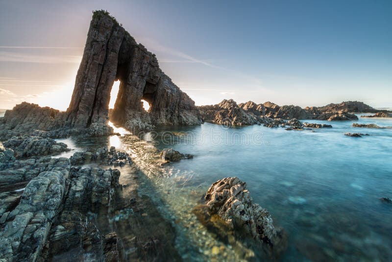 Magical monolith in Asturian beach, called the Esquiton, where the sun is filtered in summer. Magical monolith in Asturian beach, called the Esquiton, where the sun is filtered in summer