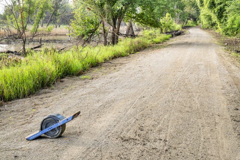 Monopatín eléctrico de Onewheel en un rastro fangoso de la bici imagen de archivo libre de regalías Monopatín eléctrico de Onewheel en un rastro fangoso de la bici imagen de archivo libre de regalías