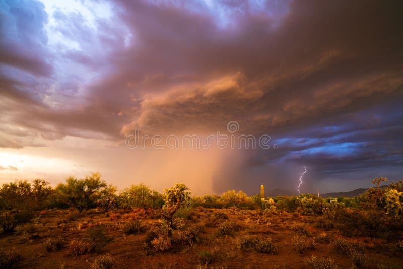 Monsoon thunderstorm with dark storm clouds and rain in the Arizona desert at sunset. Monsoon thunderstorm with dark storm clouds and rain in the Arizona desert at sunset.