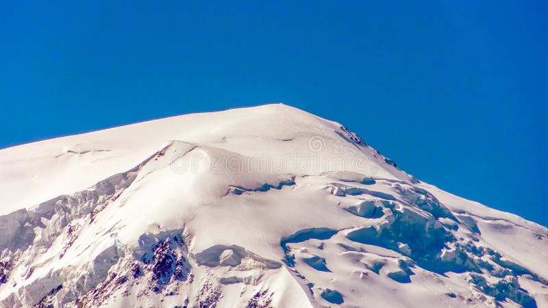 Mont Blanc is an array of high Alpine mountains in the French Alps. close - up of the peak against the blue sky stock images Mont Blanc is an array of high Alpine mountains in the French Alps. close - up of the peak against the blue sky stock images
