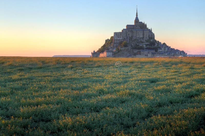 Gli ultimi raggi dorati del sole che colpisce il lato sinistro del impossing Mont Saint Michel Isola e monastero in Normandia in Francia.