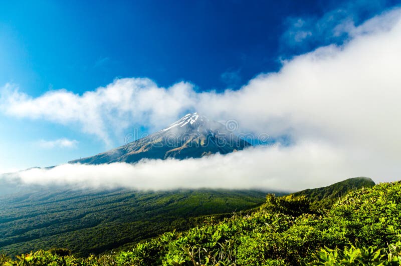 Monte Taranaki escondido por entre as nuvens imagens de stock royalty free