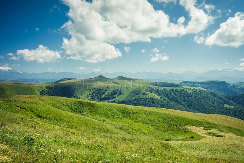 Montagne estive, erba verde e cielo azzurro fotografia stock