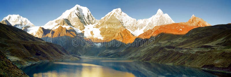 Montanhas que refletem no lago no nascer do sol