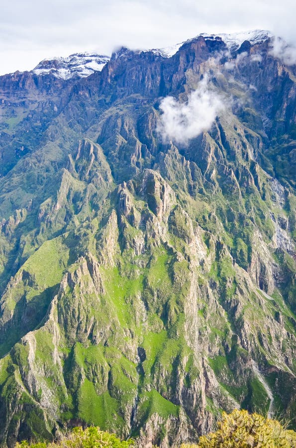 Montanhas rochosas com belas luzes e pequenas nuvens em Colca, vertical no Peru fotografia de stock royalty free Montanhas rochosas com belas luzes e pequenas nuvens em Colca, vertical no Peru fotografia de stock royalty free