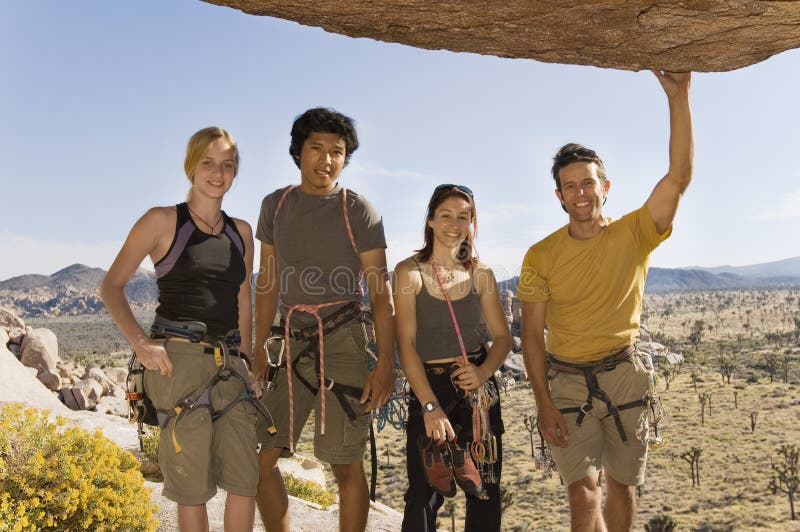 Montanhistas que estão debaixo da rocha foto de stock Montanhistas que estão debaixo da rocha foto de stock