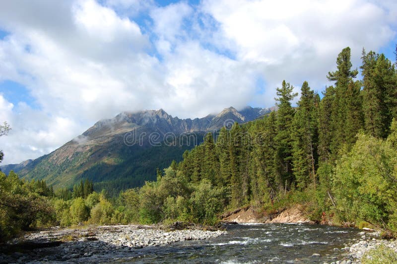 Headwaters of the mountain river and the extinct volcano. Bilin river, Sayan Mountains, Russia. Headwaters of the mountain river and the extinct volcano. Bilin river, Sayan Mountains, Russia.