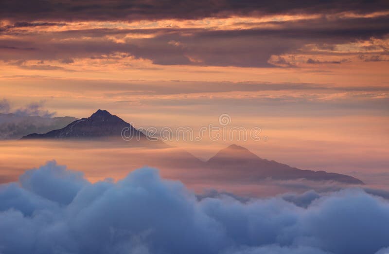 Montañas cónicas en niebla del otoño y cielo rojo por la mañana fotos de archivo Montañas cónicas en niebla del otoño y cielo rojo por la mañana fotos de archivo