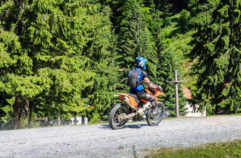 Montañas de Iezer - Rumania - 2019 Motorista joven que tiene un paseo en el bosque de las montañas de Iezer en una moto cruzada fotografía de archivo libre de regalías Montañas de Iezer - Rumania - 2019 Motorista joven que tiene un paseo en el bosque de las montañas de Iezer en una moto cruzada fotografía de archivo libre de regalías