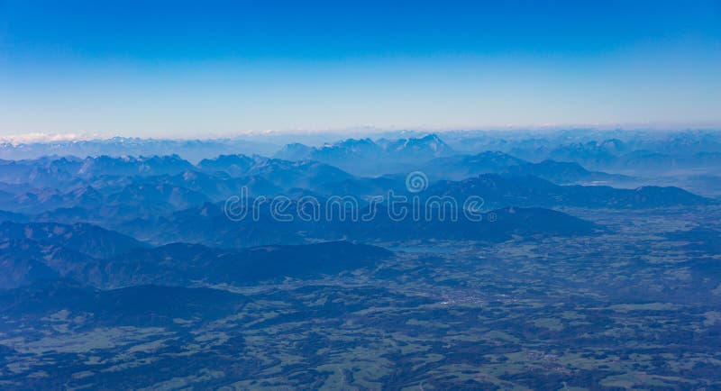 Montañas y cielo azul desde arriba Visión fuera de una ventana del aeroplano fotografía de archivo Montañas y cielo azul desde arriba Visión fuera de una ventana del aeroplano fotografía de archivo