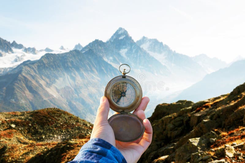 Monte Bianco mountains range and tourist hand with old metal compass