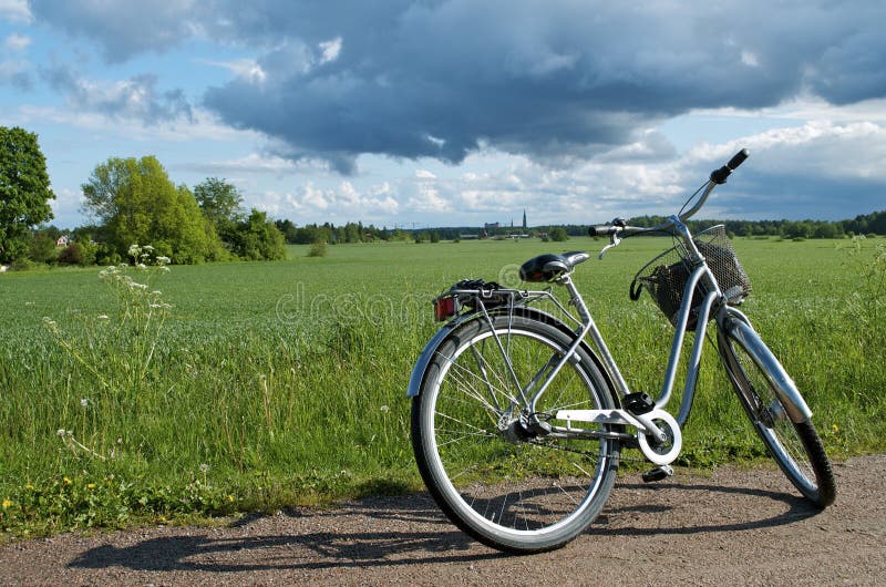 Monte en bicicleta estacionado en el borde de la carretera al lado del campo: Suecia imágenes de archivo libres de regalías Monte en bicicleta estacionado en el borde de la carretera al lado del campo: Suecia imágenes de archivo libres de regalías