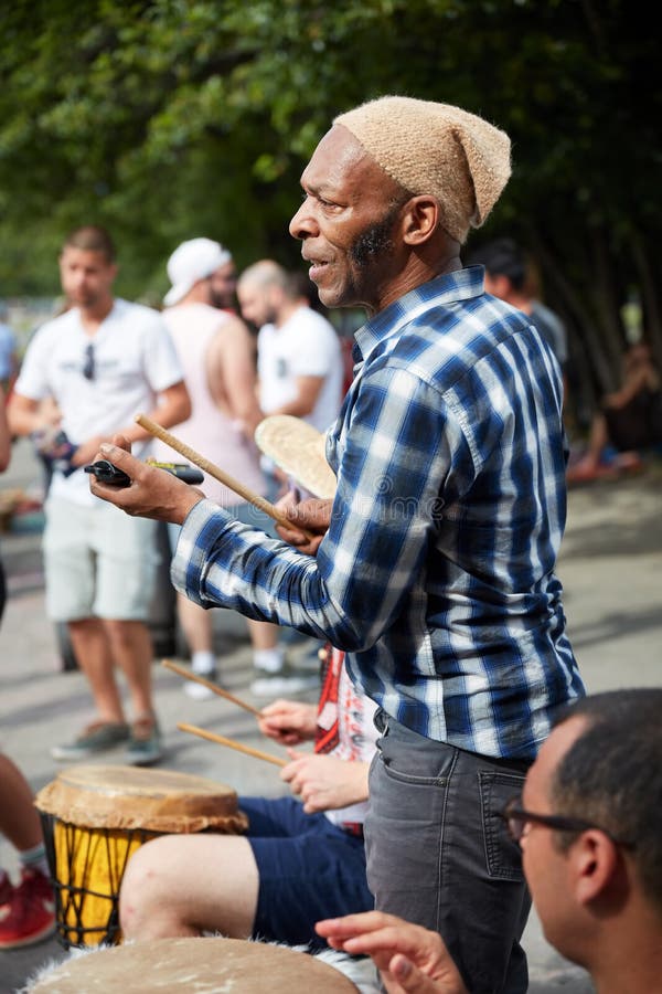 African American male percussionist playing rhythm with a cow bell at Tam Tams festival in Mount Royal Park royalty free stock photo African American male percussionist playing rhythm with a cow bell at Tam Tams festival in Mount Royal Park royalty free stock photo