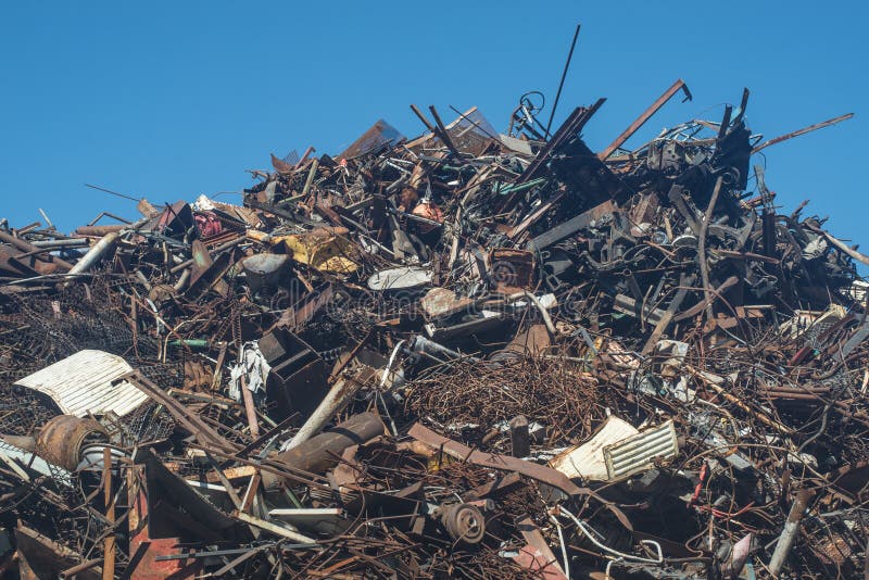 Montón de chatarra de aluminio de acero oxidado bajo cielo azul preparado para reciclarse foto de archivo libre de regalías