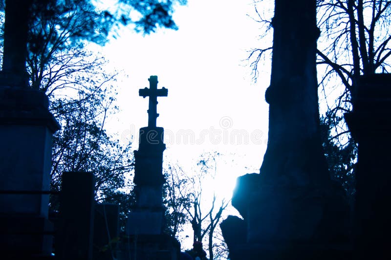 Monument and candles in the cemetery. All Saints Day in Poland. Stone sculpture. Stone angel. Stone Jesus. Stone cross.