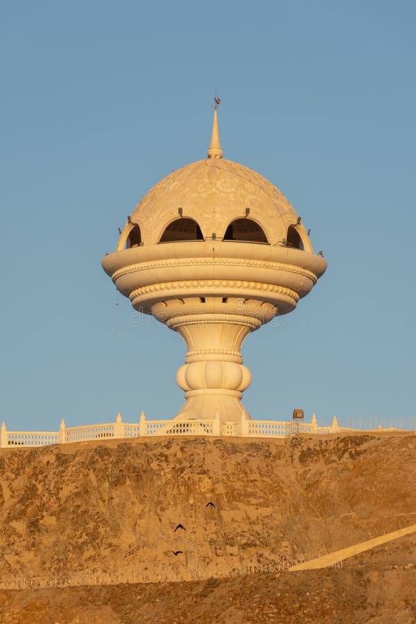 Monumento branco do queimador do incenso no parque de Riyam na cidade velha, Muscat, Omã como os grupos de incandescência do sol fotografia de stock Monumento branco do queimador do incenso no parque de Riyam na cidade velha, Muscat, Omã como os grupos de incandescência do sol fotografia de stock
