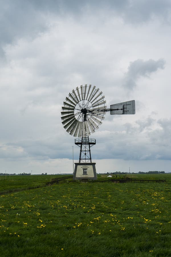 Monumento metálico del molino de viento del arquitecto de ‘Waterschap ‘ Paisaje holandés típico de Holanda Tiempo nublado con la tierra de cultivo de la hierba verde y el cielo blanco azul Las tierras de labrantío 5/14/19 de Países Bajos